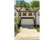 Attractive modern farmhouse-style townhome with brick accents, dark trim, and two-car garage at 125 Auburn Gate Ln, Auburn, GA 30011