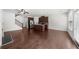 Open-concept living space with hardwood floors, a kitchen island, and staircase at 125 Auburn Gate Ln, Auburn, GA 30011