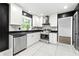 Modern kitchen featuring stainless steel appliances, stylish white cabinets, and black countertops at 2302 Aurie Dr, Decatur, GA 30034