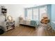 Bright bedroom featuring hardwood floors, soft blue walls, ample natural light, and a cozy swing chair at 383 Pratt Se Dr # 506, Atlanta, GA 30315