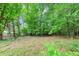 Lush backyard with mature trees and a partial fence line offering privacy at 9186 Puckett St, Covington, GA 30014