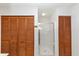 Bathroom featuring a glass-enclosed shower and wood louvered closet doors at 9186 Puckett St, Covington, GA 30014