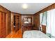 Bedroom with wood paneled walls, hardwood floors, dresser and closet at 9186 Puckett St, Covington, GA 30014