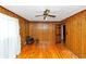 Bedroom with hardwood floors, wood paneled walls, ceiling fan, and a leather chair at 9186 Puckett St, Covington, GA 30014