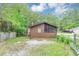 Rear exterior view of a charming home with a screened-in porch and gravel driveway at 9186 Puckett St, Covington, GA 30014