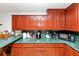 Functional kitchen with wood cabinets, green countertops, and ample counter space at 9186 Puckett St, Covington, GA 30014
