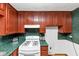 Galley kitchen features wooden cabinets, speckled counters, and a white gas range at 9186 Puckett St, Covington, GA 30014