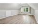 An attic space features new flooring, a window with a shutter, and updated lighting at 1520 N Milford Creek Sw Ln, Marietta, GA 30008
