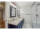 Bathroom boasts granite countertop with double sinks, modern fixtures, and a glass shower with white tile at 1520 N Milford Creek Sw Ln, Marietta, GA 30008
