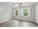 Bright bedroom with hardwood-style floors, two windows with white shutters, and neutral walls at 1520 N Milford Creek Sw Ln, Marietta, GA 30008