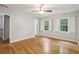 A spacious bedroom featuring hardwood floors, two windows with white shutters, and a ceiling fan at 1520 N Milford Creek Sw Ln, Marietta, GA 30008