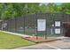 Fenced community tennis court with black windscreen and access gate for neighborhood residents at 1520 N Milford Creek Sw Ln, Marietta, GA 30008