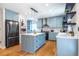This light blue kitchen offers an island, stainless appliances, hardwood floors and updated lighting at 333 Mimosa Dr, Decatur, GA 30030