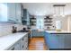 Light blue kitchen with hardwood floors and white subway tile backsplash, open floating shelves and gas cooktop at 333 Mimosa Dr, Decatur, GA 30030
