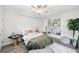 Bright bedroom featuring a ceiling fan, painted brick wall, wood flooring, and charming built-in shelving unit at 1222 Crestwood Se Dr, Atlanta, GA 30316
