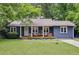 Charming blue painted brick home featuring a covered porch and a well manicured lawn at 1222 Crestwood Se Dr, Atlanta, GA 30316