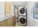 Laundry room with stacked washer/dryer units, wooden cabinets and countertops, and natural light at 1222 Crestwood Se Dr, Atlanta, GA 30316