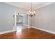 Cozy dining space showcasing hardwood flooring, a classic chandelier, and open access to another living area at 1640 Arbor Green Nw Ct # 1102, Kennesaw, GA 30152
