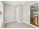 A bright bedroom with gray walls and carpeting, leading to a kitchen with white cabinets and modern appliances at 3417 Glen Rd, Decatur, GA 30032
