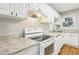 Well-lit kitchen featuring stainless appliances, granite countertops, and white cabinets at 3417 Glen Rd, Decatur, GA 30032