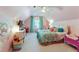 Pink bedroom with sloped ceiling, TV, toy storage, window with shades, and a colorful comforter at 3803 Mill Creek Ct, Atlanta, GA 30341