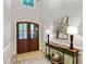 Welcoming foyer with wood doors, decorative table, marble flooring and art at 3803 Mill Creek Ct, Atlanta, GA 30341