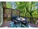 Outdoor dining area on a wooden deck, complete with a grill, table, chairs, and privacy lattice at 3803 Mill Creek Ct, Atlanta, GA 30341