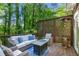 Cozy outdoor patio with comfortable seating, a fire pit, and privacy lattice, surrounded by lush trees at 3803 Mill Creek Ct, Atlanta, GA 30341