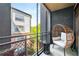 Relaxing balcony area with stylish seating, side table, and serene views of the surrounding buildings and nature at 400 17Th Nw St # 1315, Atlanta, GA 30363