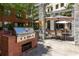 Outdoor kitchen area featuring a grill and adjacent patio seating area with tables and shade umbrellas at 400 17Th Nw St # 1315, Atlanta, GA 30363