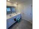 Bright bathroom featuring double sinks, a large mirror, and a modern blue step stool at 4685 Trefoil Path, Cumming, GA 30040