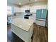 Bright kitchen with island, stainless appliances, granite countertops and white cabinets at 4685 Trefoil Path, Cumming, GA 30040