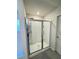 Modern walk-in shower with clear glass enclosure, shelving, and neutral tile surround at 4685 Trefoil Path, Cumming, GA 30040