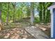 Expansive backyard with mature trees and partial concrete patio at 5126 Farm Place Ne Dr, Woodstock, GA 30188