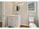 Bright bathroom with a modern vanity, round mirror and wood-look floors at 5126 Farm Place Ne Dr, Woodstock, GA 30188