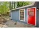 Exterior showcases updated siding, vibrant red door and view of a concrete patio at 5126 Farm Place Ne Dr, Woodstock, GA 30188