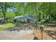 Inviting blue home boasts mature trees, a red front door, and a welcoming driveway at 5126 Farm Place Ne Dr, Woodstock, GA 30188