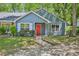 Charming blue home features a bright red front door, large window, and well-maintained lawn at 5126 Farm Place Ne Dr, Woodstock, GA 30188