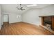 Large living room with hardwood floors, skylights, and fireplace with a rustic mantel at 5126 Farm Place Ne Dr, Woodstock, GA 30188