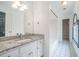 Bathroom vanity features granite countertop, bright lighting, and white cabinetry, with tile flooring extending to the bath at 1751 Bergen Ct, Lawrenceville, GA 30043
