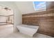 Stylish main bathroom showcasing a soaking tub with wood-look tile accent wall at 1751 Bergen Ct, Lawrenceville, GA 30043