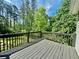 View of a stained wooden deck overlooking a lush, green wooded area, perfect for outdoor relaxation at 41 Jessica Ln, Dallas, GA 30157