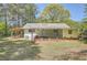 A view of the back exterior, showcasing the covered patio, yard, and charming details at 4201 Regal Ridge Rd, Austell, GA 30106