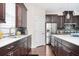 Well-lit kitchen with dark wood cabinets, stainless steel appliances, light countertops, and mosaic backsplash, offering a modern touch at 524 Tackett Farms Rd, Smyrna, GA 30082