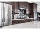Bright kitchen with stainless steel appliances, dark wood cabinets, subway tile backsplash, and a large island, offering a contemporary feel at 524 Tackett Farms Rd, Smyrna, GA 30082