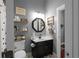 The well-lit bathroom has a modern vanity with dark wood and decor at 9988 Devonshire St, Douglasville, GA 30135