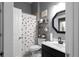 The well-lit bathroom features a modern vanity, decor, and a black and white shower curtain at 9988 Devonshire St, Douglasville, GA 30135
