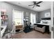 Bright bedroom features a bed, workout bike, desk with chair, and decorative wall art at 9988 Devonshire St, Douglasville, GA 30135