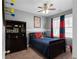 Cozy bedroom with natural lighting, blue and red accents, and carpeted floors at 9988 Devonshire St, Douglasville, GA 30135