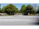 Community entrance with stone signage, flowering plants, and mature trees at 9988 Devonshire St, Douglasville, GA 30135